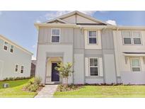Charming townhome showcasing a two-story facade, manicured lawn, and welcoming front entrance at 16129 Palm Frond Ave, Clermont, FL 34714