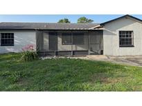 A cozy backyard showing the screened-in porch, grass, and landscaping around this cozy home at 2085 San Jose Blvd, Orlando, FL 32808