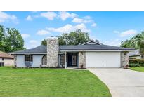 Charming single-story home with a stone facade, attached two-car garage, and well-maintained lawn at 229 Marcum Trace Dr, Lakeland, FL 33809