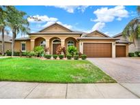 Beautiful single-story home featuring a well-manicured lawn, brick driveway, and a spacious three-car garage at 2313 Pesaro Cir, Ocoee, FL 34761