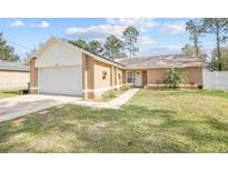 Charming single-story home featuring a two-car garage, well-maintained lawn, and lovely landscaping at 3149 Quail Dr, Deltona, FL 32738