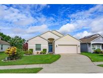 Charming single-story home featuring a well-manicured lawn and two car garage under a sunny sky at 4642 Waterside Pointe Cir, Orlando, FL 32829