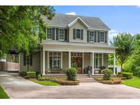 Stately two-story home with a welcoming front porch, beautiful landscaping, and a brick driveway at 685 Mayo Ave, Maitland, FL 32751
