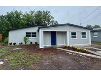 Charming single story home featuring a blue door, fresh exterior paint and landscaping at 8320 Dominguin St, Orlando, FL 32817