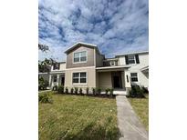 Inviting two-story townhome with a well-manicured lawn and neutral-toned facade at 10624 Words Dr, Winter Garden, FL 34787