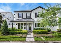 Charming two-story home featuring black accents, manicured landscaping, and a welcoming brick walkway at 1414 W New Hampshire St, Orlando, FL 32804