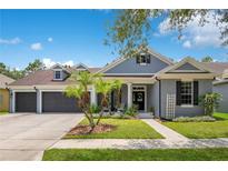 Charming one-story home with landscaped front yard, gray paint, black shutters, and a spacious three-car garage at 14306 Paradise Tree Dr, Orlando, FL 32828