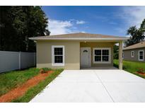 Tan single story home with a modern design, concrete driveway, and a well-maintained, landscaped yard at 144 Mandrake St, Orlando, FL 32811