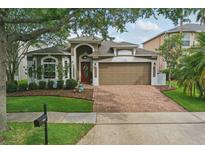 Charming single-Gathering home featuring a brick driveway, a well-maintained lawn, and a two-car garage at 15038 Masthead Landing Cir, Winter Garden, FL 34787