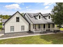 Charming two-story modern farmhouse with a covered porch and manicured lawn at 2050 Jan Lan Blvd, St Cloud, FL 34772