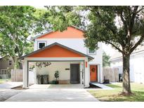 Charming two-story home with a carport, orange accents, and well-maintained landscaping at 312 W Hull Ave, Oakland, FL 34760