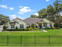 Stunning white farmhouse-style home featuring a beautifully landscaped front yard with a black metal fence and lush green grass at 340 Lakeview Rd, Winter Garden, FL 34787