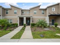 Inviting townhouse showcasing a modern design, landscaped front yard, and a neatly paved walkway at 4363 Scene Ln, Kissimmee, FL 34746