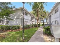 Beautifully landscaped apartment buildings with lush green grass and mature trees on a sunny day at 563 Midway Trak # K102, Ocala, FL 34472