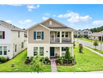 Charming two-story home showcasing a cozy front porch and beautiful, well-maintained landscaping at 11006 Sound Shore Dr, Winter Garden, FL 34787