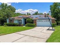 Charming single-story home with solar panels, lush landscaping, and a two-car garage at 1032 Silcox Branch Cir, Oviedo, FL 32765