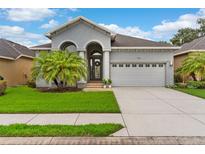 Lovely single-Gathering home boasting a manicured lawn, lush landscaping, and an attached two-car garage at 1035 Stoney Creek Dr, Lakeland, FL 33811