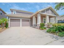 Two-story home featuring a two-car garage, covered porch, and well-maintained landscaping at 13940 Magnolia Ridge Loop, Winter Garden, FL 34787