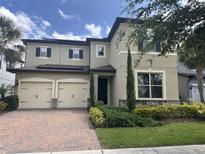 Charming two-story home featuring a three-car garage, landscaped yard, and classic architectural details at 14117 Larkspur Lake Dr, Winter Garden, FL 34787