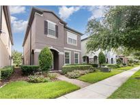 Charming two-story home featuring a landscaped yard, complemented by a brick pathway and well-maintained lawn at 14215 Lakeview Park Rd, Winter Garden, FL 34787