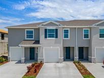 Charming townhome showcasing a well-maintained facade, single-car garages and manicured landscaping at 1518 Isleta Loop, Kissimmee, FL 34741