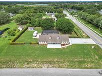 Expansive aerial view of a home showcasing a large lot, screened pool, RV, and mature trees at 15650 Catherine Cir, Groveland, FL 34736