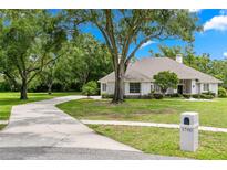 Stunning single-story home with a lush front yard, mature trees, and long driveway at 1700 Shandwick Ct, Longwood, FL 32779