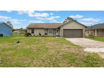 Charming single-Gathering home featuring stone accents, a well-manicured lawn, and an attached two-car garage at 1785 6Th Ave, Deland, FL 32724