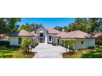 Stunning exterior of a home with meticulous landscaping and a permeable paver driveway at 5199 Latrobe Dr, Windermere, FL 34786