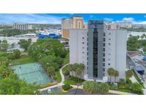 Exterior view of a hotel and suites building with a tennis court in the foreground at 6165 Carrier Dr # 2605, Orlando, FL 32819