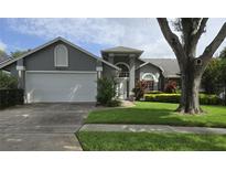 Charming gray two-story home with landscaped yard, mature tree, and a two car garage at 651 Oak Hollow Way, Altamonte Springs, FL 32714