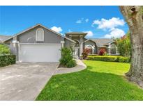 Charming home with a two-car garage, manicured lawn, and colorful landscaping enhancing its curb appeal at 651 Oak Hollow Way, Altamonte Springs, FL 32714
