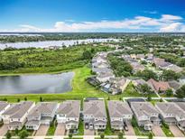 Beautiful aerial view of a neighborhood with houses surrounding a lake and lush greenery at 6947 Cucamelon Ct, Windermere, FL 34786