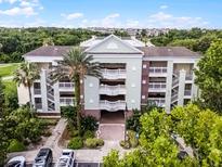 Beautiful condo building featuring multiple stories, private balconies, lush landscaping, and ample parking at 7616 Cabana Ct # 301, Reunion, FL 34747