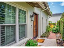 Charming home entrance with brick path, lush landscaping, and a stylish wooden front door at 830 Oak St, Orlando, FL 32804