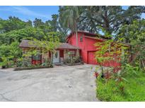 Charming red home with stone accents, lush landscaping, and a welcoming front entrance at 874 Quarters Ct, Port Orange, FL 32129