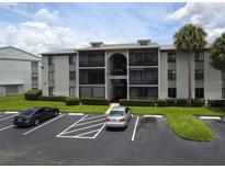 Exterior of the condo featuring a parking lot and well-maintained landscaping at 1221 S Pine Ridge Cir # A2, Sanford, FL 32773