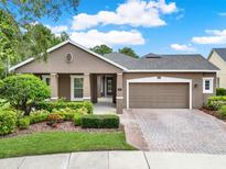 Charming one-story home with a well-manicured lawn, brick driveway, and neutral-colored exterior at 1375 Brayford Point, Deland, FL 32724