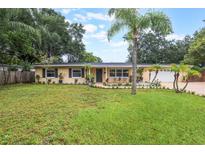 Charming single-story home featuring a well-manicured lawn and decorative palm trees for added curb appeal at 1405 Montclair Ct, Orlando, FL 32812