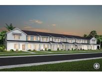Row of townhomes in a planned community featuring modern farmhouse architecture and well-manicured lawns at 2349 Southbury Dr, Kissimmee, FL 34744