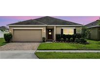 Charming single-story home with brick driveway and manicured lawn and a two car garage at 267 Williamson Dr, Davenport, FL 33897