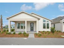 Charming single-story home featuring a covered front porch and stylish blue front door, surrounded by fresh landscaping at 2926 Sailhouse Drive, St Cloud, FL 34771