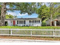 Charming single-story home with a bright red door, white picket fence, and lush landscaping at 441 S Primrose Dr, Orlando, FL 32803