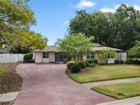 Charming home featuring a brick-stamped driveway, well-manicured lawn, and mature landscaping, creating excellent curb appeal at 501 Benedict Ct, Casselberry, FL 32707