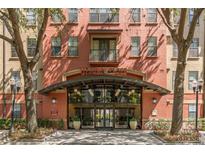 Stylish building entrance featuring an arched canopy, glass doors, and well-maintained landscaping at Uptown Place at 911 N Orange Ave # 440, Orlando, FL 32801