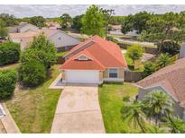 Aerial view of charming single-story home with a well-maintained lawn and a red roof at 10360 Crystal Point Dr, Orlando, FL 32825