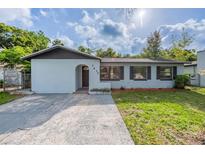 Charming single-story home with light blue paint, neat front lawn, and welcoming arched entryway at 1417 Pine Lake Rd, Orlando, FL 32808