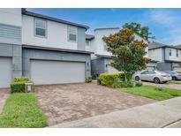 Modern townhome showcasing a two-car garage and neatly landscaped front yard on a sunny day at 1624 Little Wren Ln, Winter Park, FL 32792