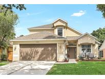 Charming two-story home featuring a well-manicured lawn, a brown garage door, and a cozy front porch area at 1932 Westpointe Cir, Orlando, FL 32835