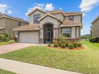 Beautiful two-story home featuring a well-manicured lawn, tile roof, and attached two-car garage at 2105 Lake Side Ave, Davenport, FL 33837